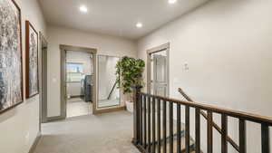 Corridor with an upstairs landing, carpet, and recessed lighting