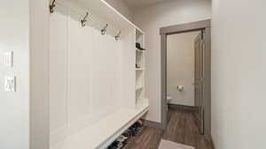 Mudroom featuring dark wood finished floors and baseboards