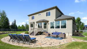 Back of house with stucco siding, a fenced backyard, a patio area, an outdoor living space, and a shingled roof