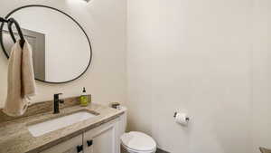 Half bathroom featuring vanity and toilet