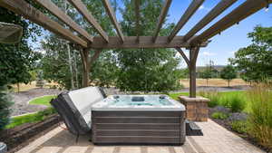 View of patio / terrace featuring a hot tub and a pergola