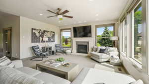 Living room featuring a ceiling fan, carpet floors, a glass covered fireplace, and recessed lighting