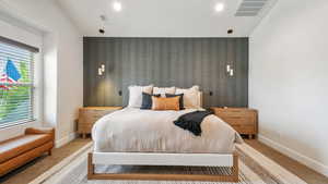 Bedroom with carpet, lofted ceiling, an accent wall, and recessed lighting