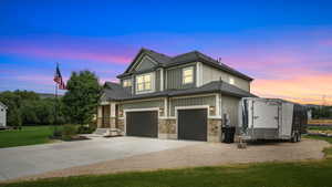 Craftsman-style house with concrete driveway, an attached garage, stone siding, a front lawn, and roof with shingles