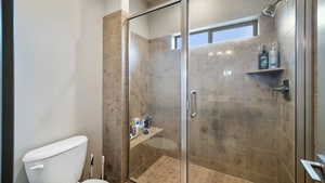 Full bath featuring toilet and a shower stall