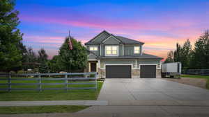 Craftsman house featuring a garage, driveway, board and batten siding, and stone siding