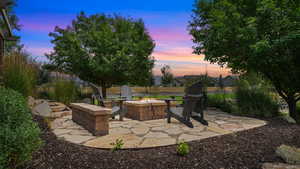 Patio terrace at dusk featuring an outdoor fire pit and a patio area