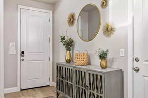 Entryway with light wood finished floors and baseboards