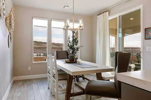 Dining room with a chandelier, light wood-style floors, and a mountain view