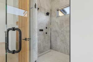 Bathroom featuring a marble finish shower