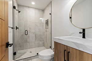 Full bathroom with vanity, a stall shower, and recessed lighting