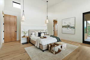 Bedroom featuring high vaulted ceiling, light wood-type flooring, and access to outside