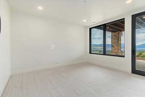Empty room featuring carpet floors, recessed lighting, and a mountain view