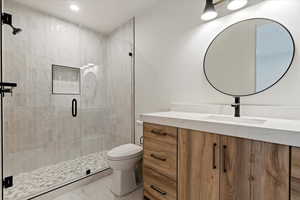 Bathroom with vanity, a stall shower, tile patterned floors, and recessed lighting
