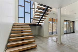Stairway featuring concrete flooring and baseboards