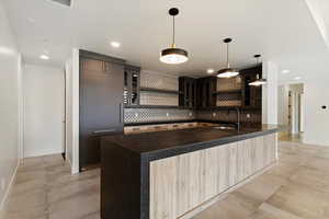 Kitchen featuring open shelves, backsplash, concrete flooring, recessed lighting, and glass insert cabinets