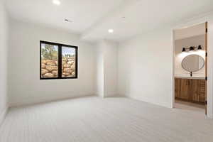 Unfurnished bedroom featuring light colored carpet, recessed lighting, and ensuite bath