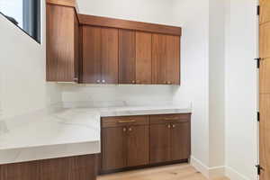 Kitchen featuring light stone counters, light wood-style flooring, and modern cabinets