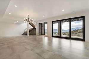 Unfurnished living room with recessed lighting, a mountain view, stairway, and a chandelier