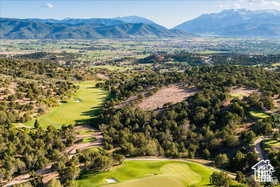 Bird's eye view of a golf course and a mountainous background