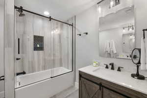 Bathroom with vanity, enclosed tub / shower combo, and tile patterned flooring