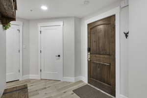 Foyer entrance featuring light wood-style floors and baseboards