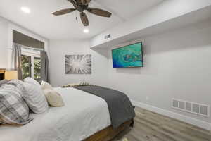 Bedroom with wood finished floors, a ceiling fan, and recessed lighting