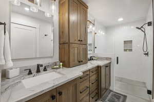 Primary bath with double vanity, a stall shower, and recessed lighting