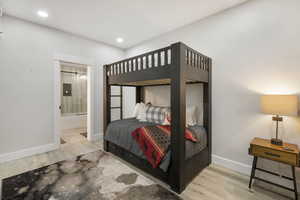 Bedroom featuring wood finished floors, connected bathroom, and recessed lighting