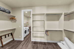 Walk in closet featuring washer and clothes dryer and dark wood-type flooring