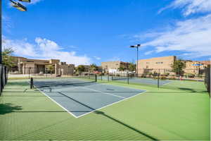 View of tennis court featuring community basketball court and a residential view