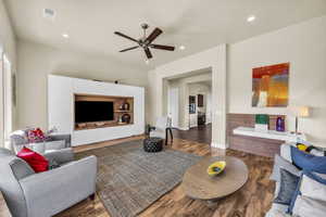 Living room with a ceiling fan, wood finished floors, and recessed lighting