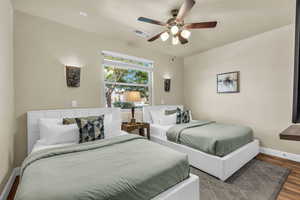 Bedroom with wood finished floors, a textured ceiling, and a ceiling fan
