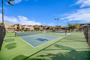 View of tennis court with a residential view
