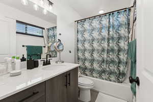 Bathroom with vanity and shower / bath combo with shower curtain