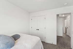 Carpeted bedroom with a closet and baseboards