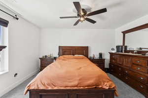 Bedroom featuring dark carpet, a textured ceiling, and a ceiling fan