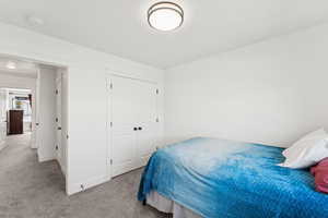 Carpeted bedroom featuring a closet and baseboards
