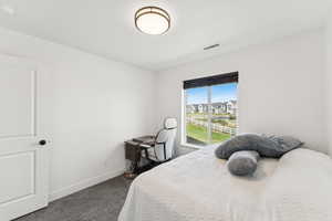 Bedroom featuring dark colored carpet and a textured ceiling