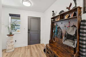 Mudroom with light wood finished floors and baseboards