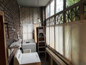 Washroom featuring independent washer and dryer and brick wall