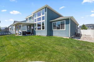 Rear view of house with a trampoline, a fenced backyard, a patio, and stucco siding