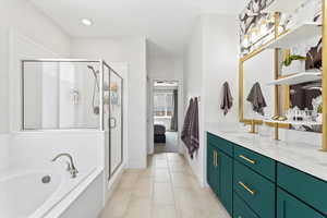 Bathroom featuring double vanity, a garden tub, a stall shower, ensuite bath, and recessed lighting