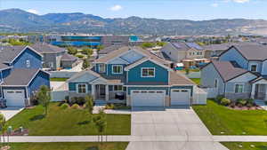 View of front facade featuring a residential view, concrete driveway, an attached garage, and a mountain view