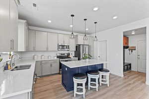 Kitchen featuring stainless steel appliances, a kitchen breakfast bar, light wood finished floors, a center island, and recessed lighting