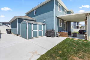 Rear view of house featuring a shed, a patio area, outdoor lounge area, and stucco siding