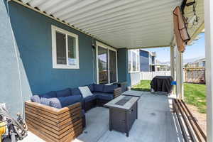 Fenced backyard featuring an outdoor living space with a fire pit, a patio, and area for grilling