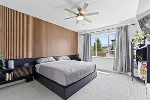 Carpeted bedroom featuring a ceiling fan