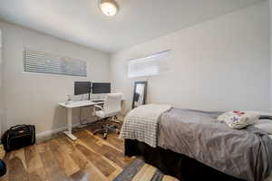Bedroom with hardwood / wood-style floors and an office area