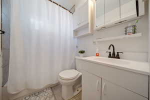 Full bath with vanity, tile patterned flooring, and shower / bath combo with shower curtain